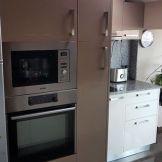 Кухня капучино и бял гланц с плот и гръб гранит